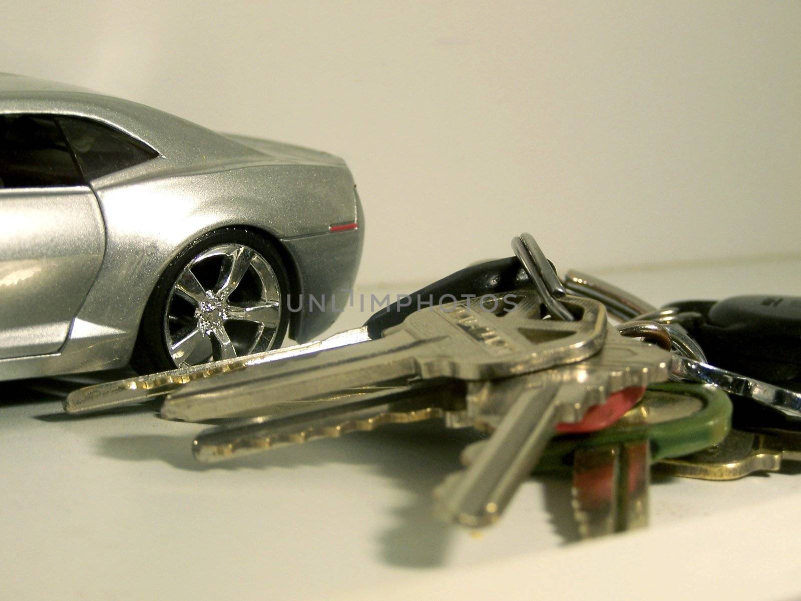 Shiny silver car with car keys in the foreground. Auto loan, auto financing, auto sale for buyer.