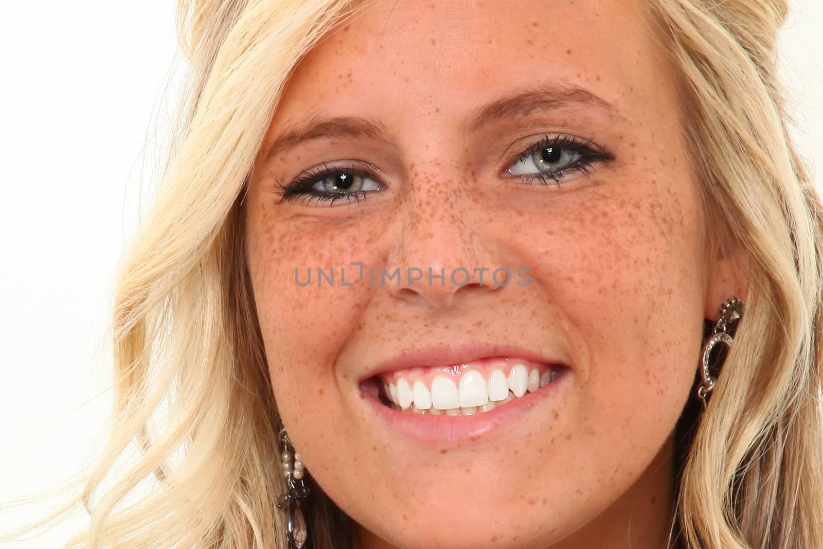 Beautiful young woman with perfect teeth smiling over white background.  Close up.