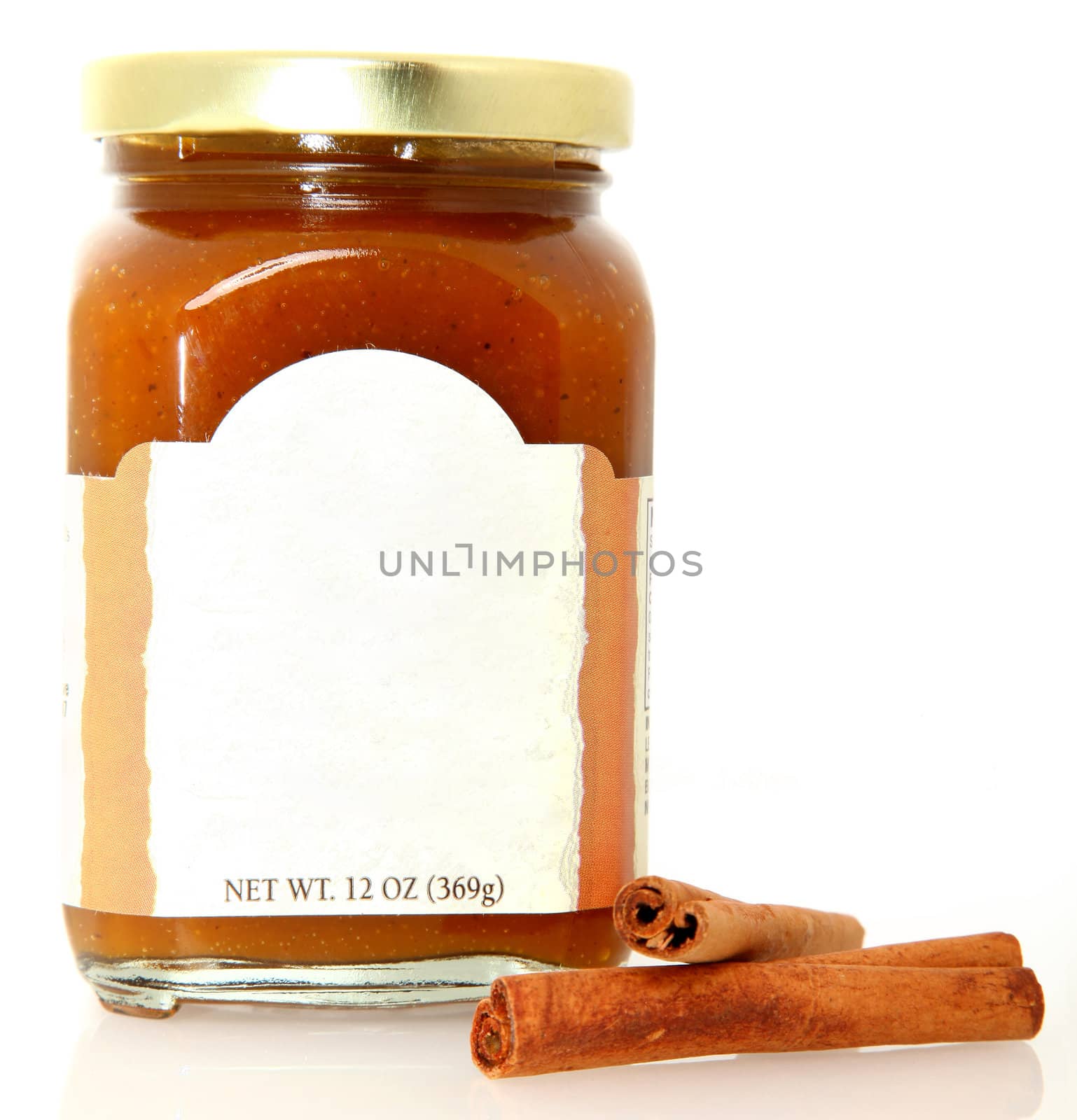 Pumpkin spice butter in jar with cinnamon sticks over white.  Blank label for text.