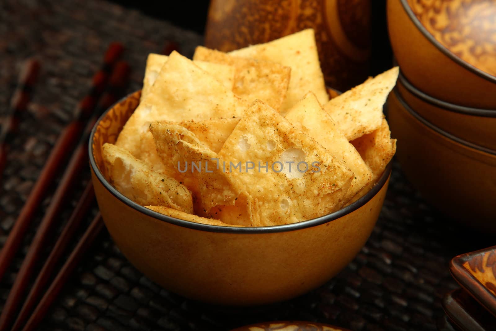 Bowl of seasoned homemade organic pita chips in kitchen setting.