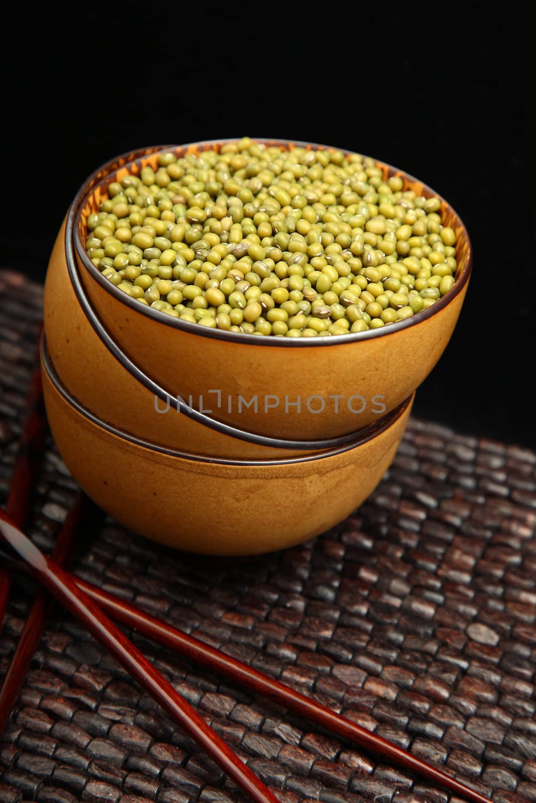 Raw mung in asian bowl with chopsticks, in kitchen.