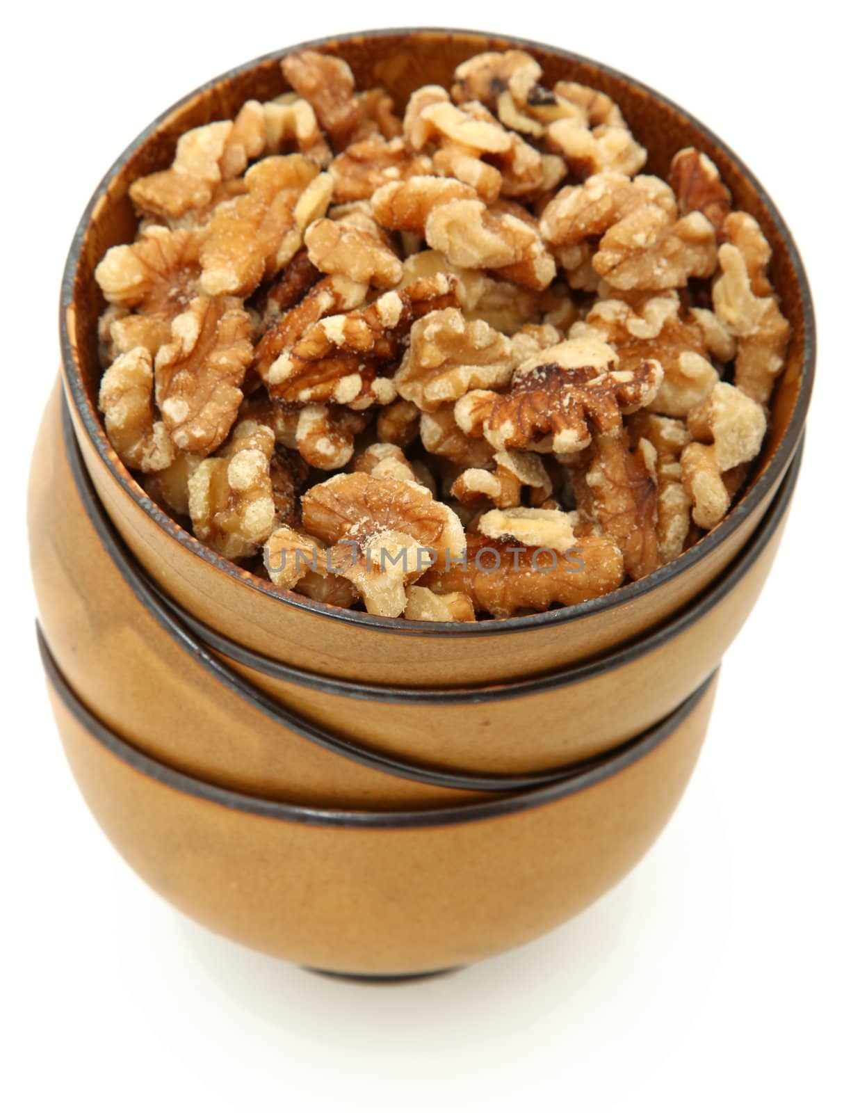 Stack of bowls filled with walnuts over white background.