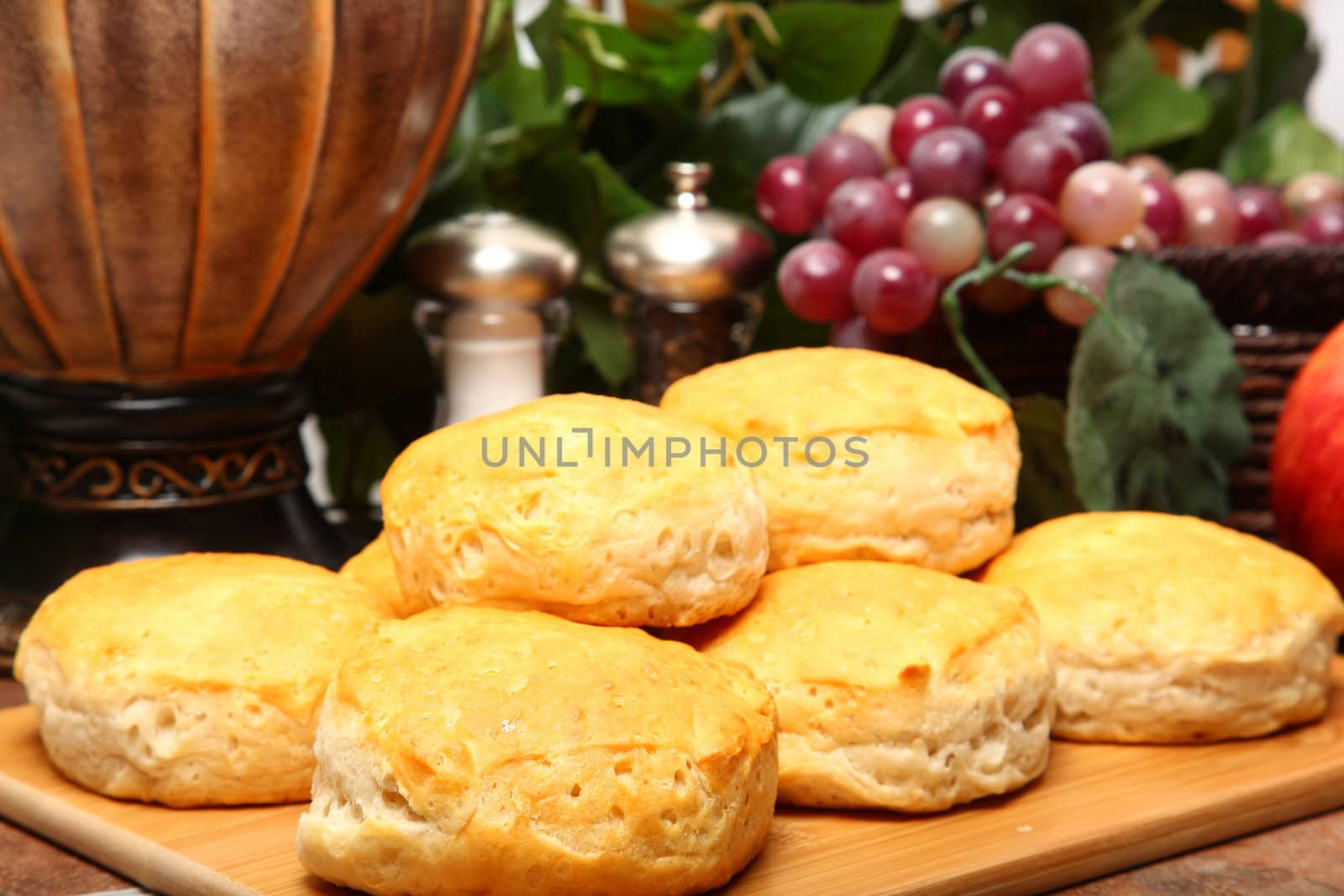 Stack of hot fresh breakfast biscuits on cutting board in kitchen.