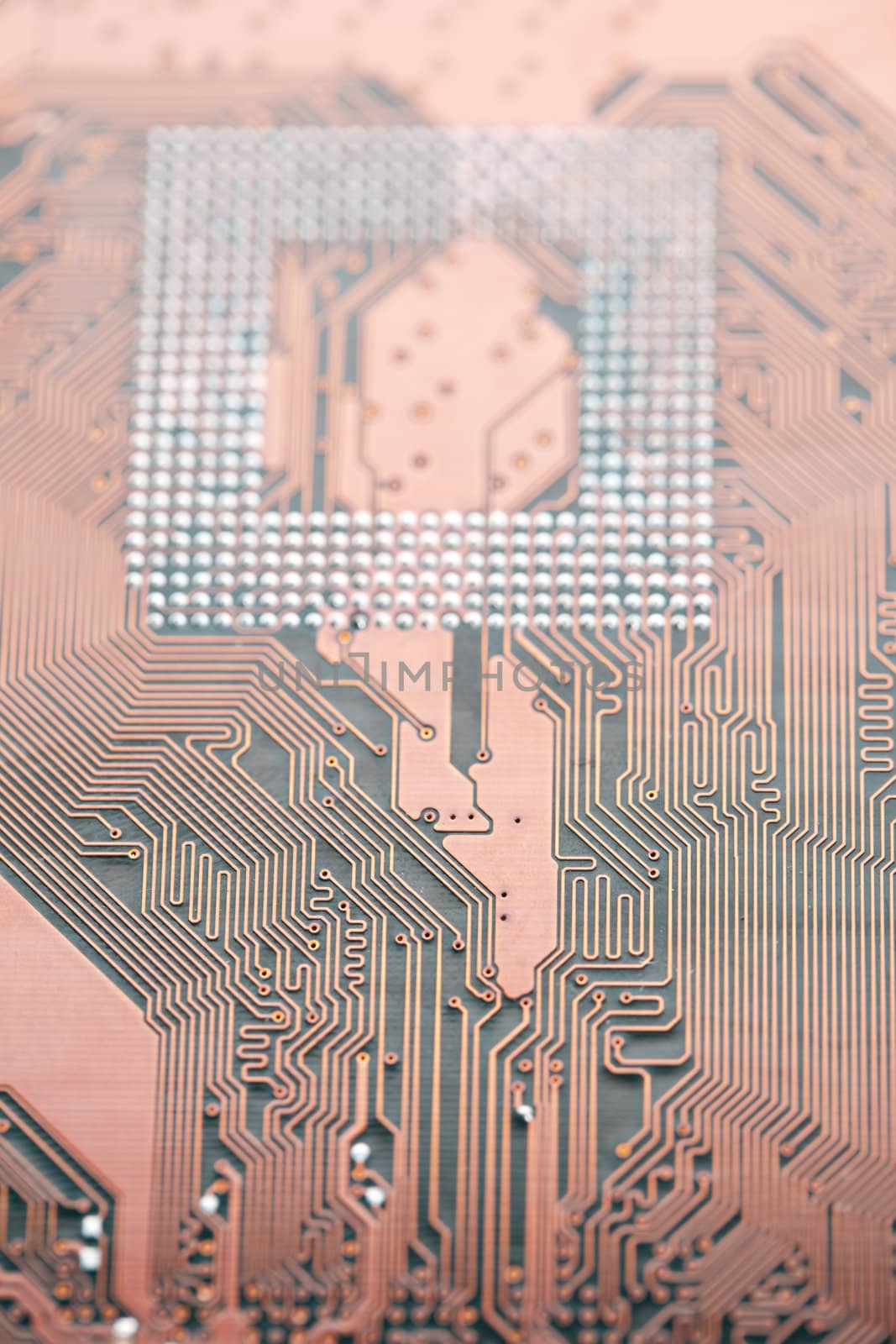 A close up shot of the backside of a computer circuit board, also known as a motherboard.