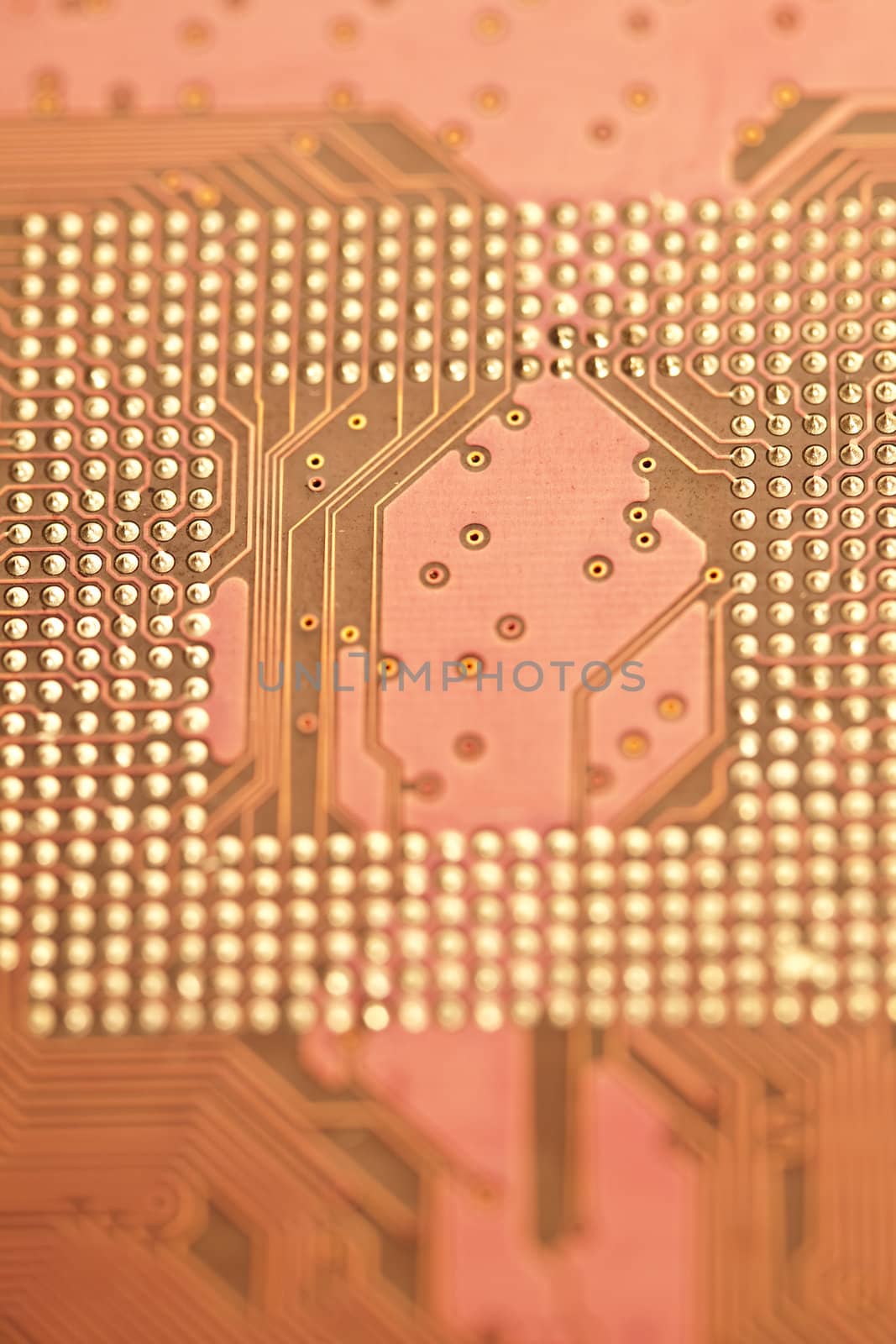 A close up shot of the backside of a computer circuit board, also known as a motherboard.