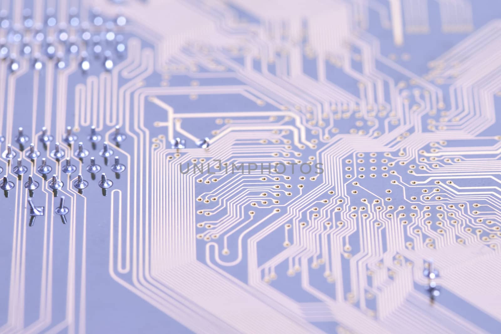 A close up shot of the backside of a computer circuit board, also known as a motherboard.