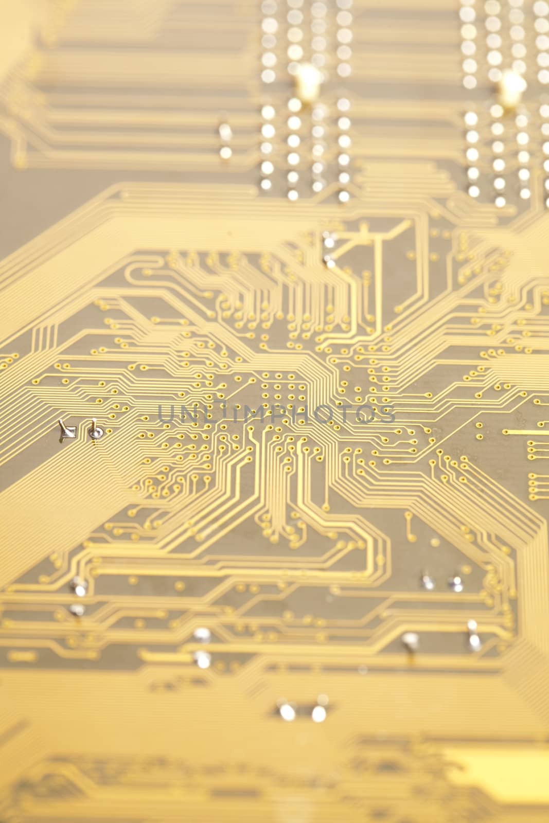 A close up shot of the backside of a computer circuit board, also known as a motherboard.