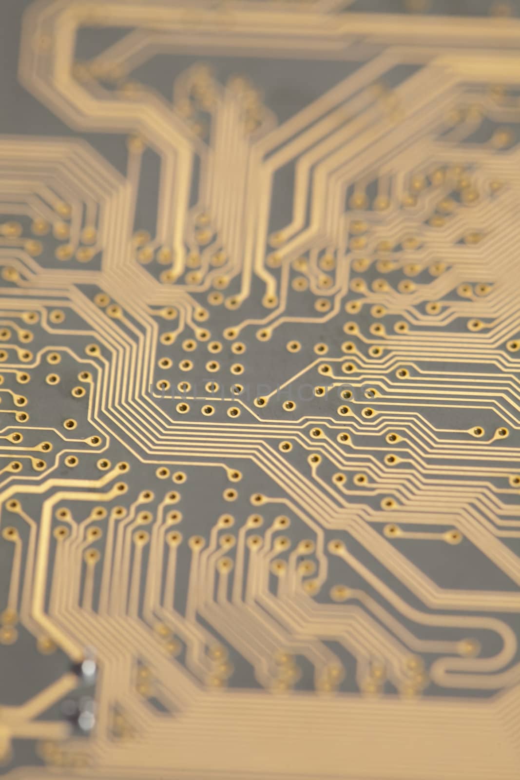 A close up shot of the backside of a computer circuit board, also known as a motherboard.