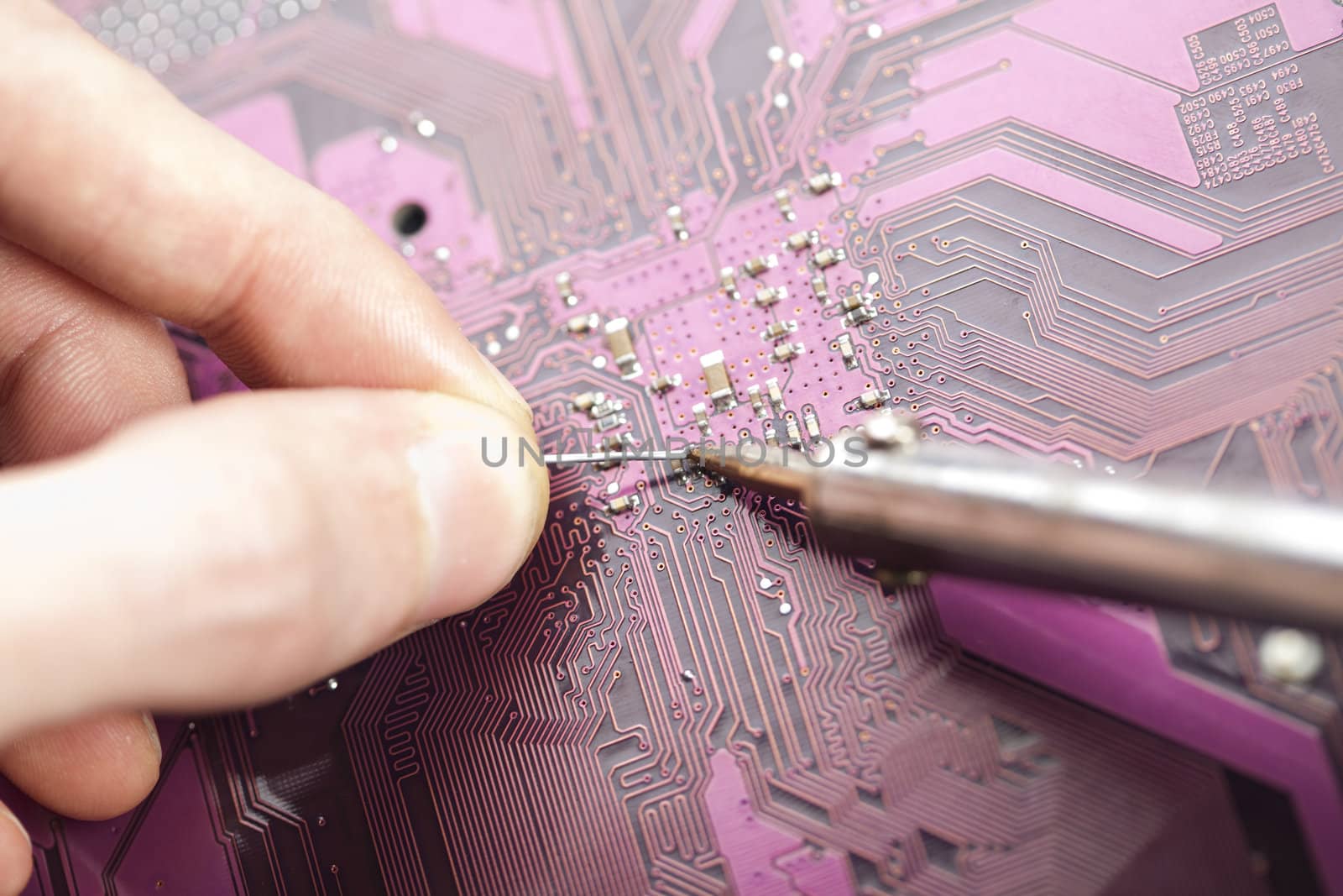 A close up shot of the backside of a computer circuit board, also known as a motherboard.