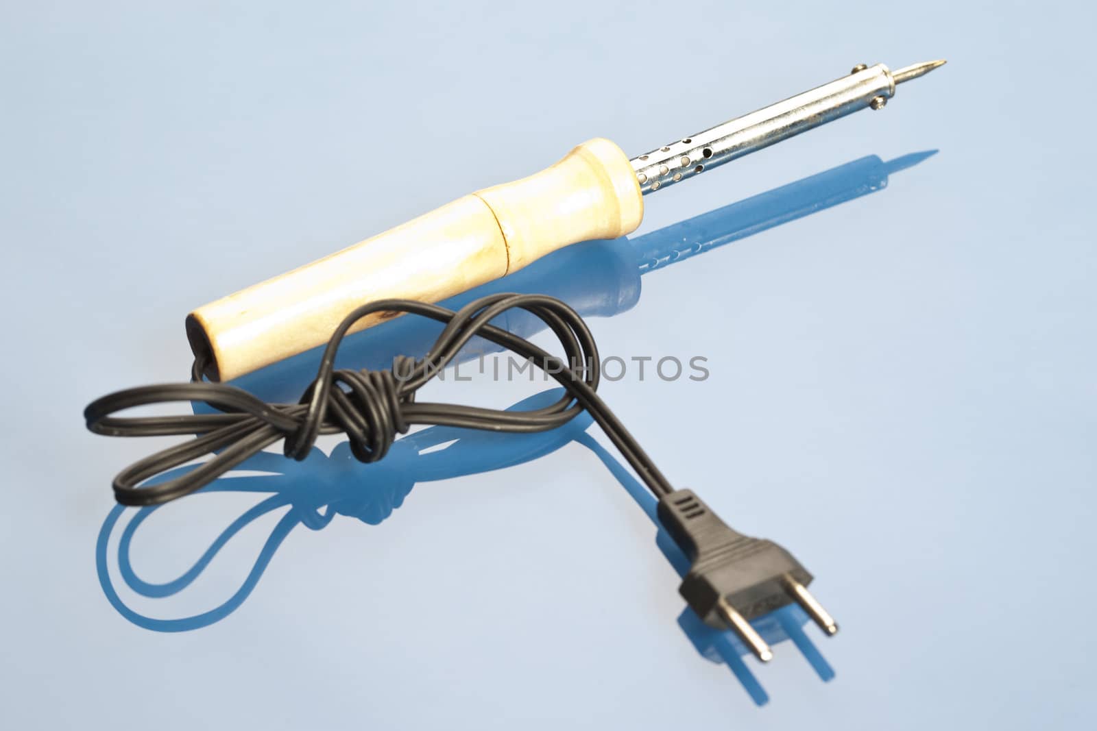 Solidering iron on a blue background