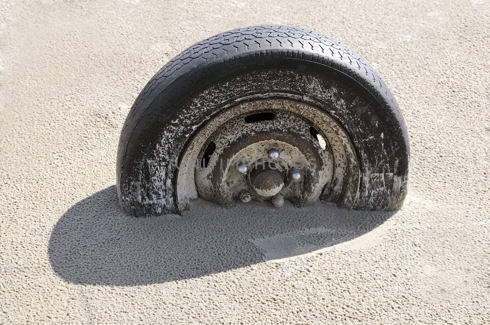 Vehicle wheel in sand. The wheel is half filled up by sand