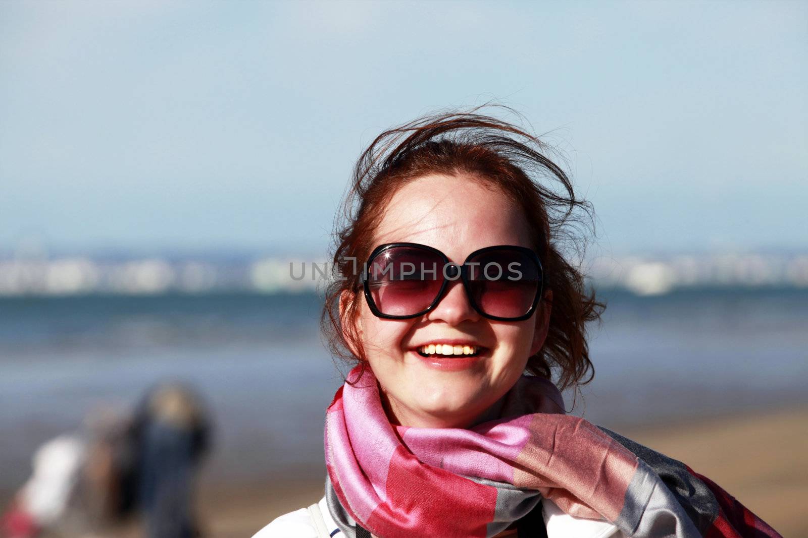 The happy girl in solar glasses on a beach