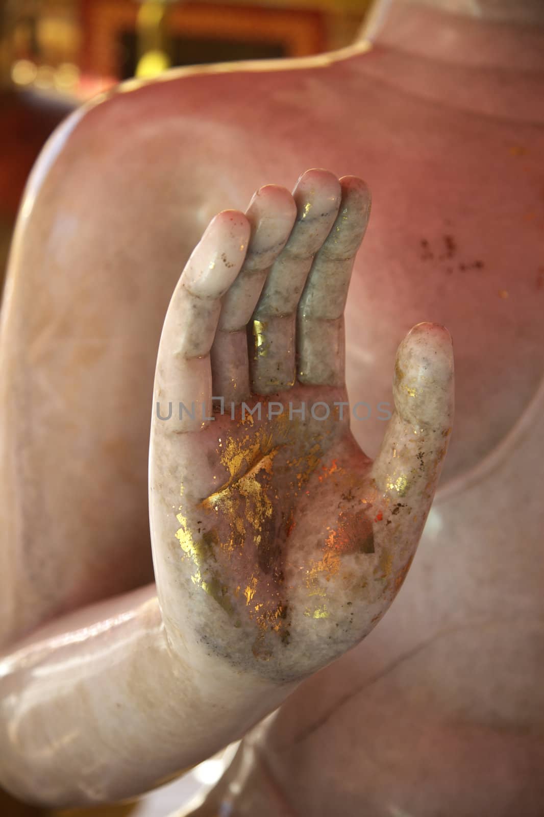 Golden and raised hand of a Buddha - upright format