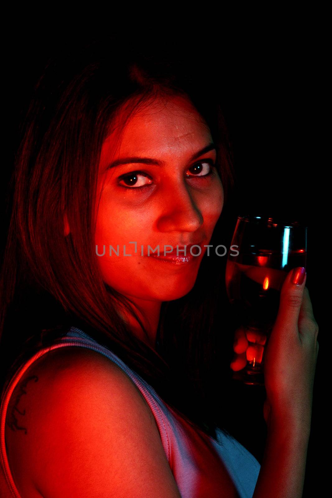 A portrait of a beautiful Indian lady drinking wine.