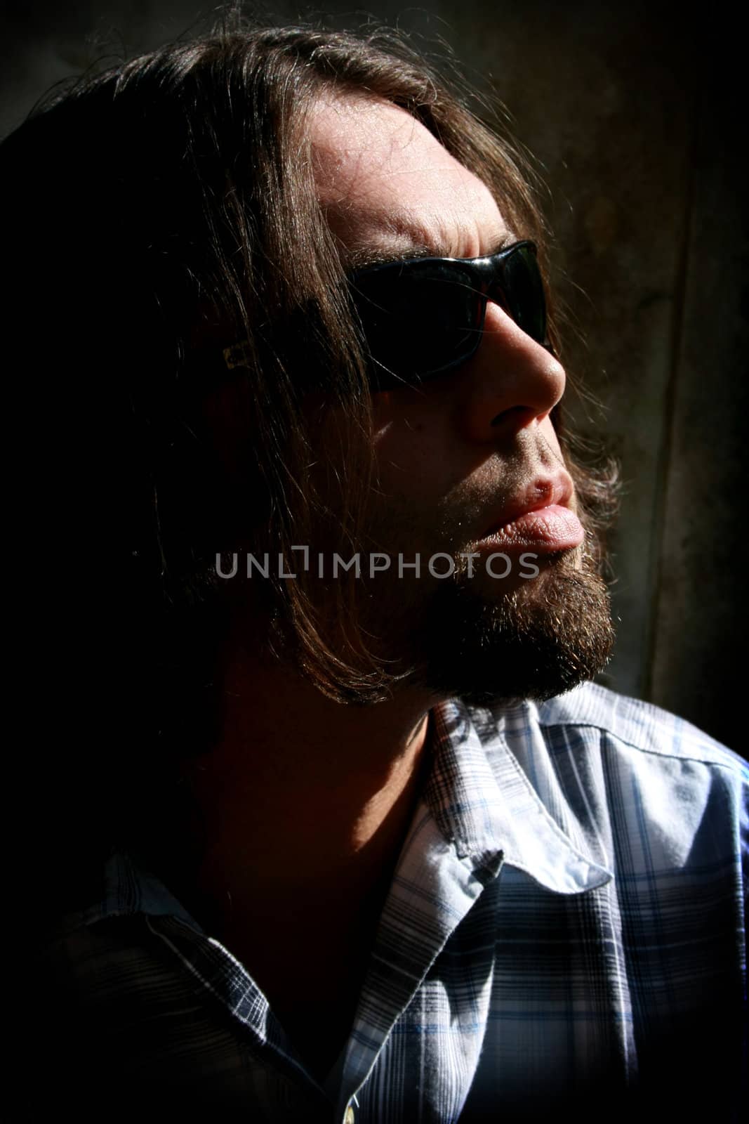 Long haired man with sunglasses in a low key shot