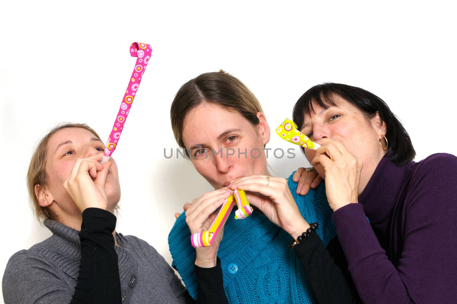 Two young women and her mother celebrating New year's eve. Shot taken in front of white background