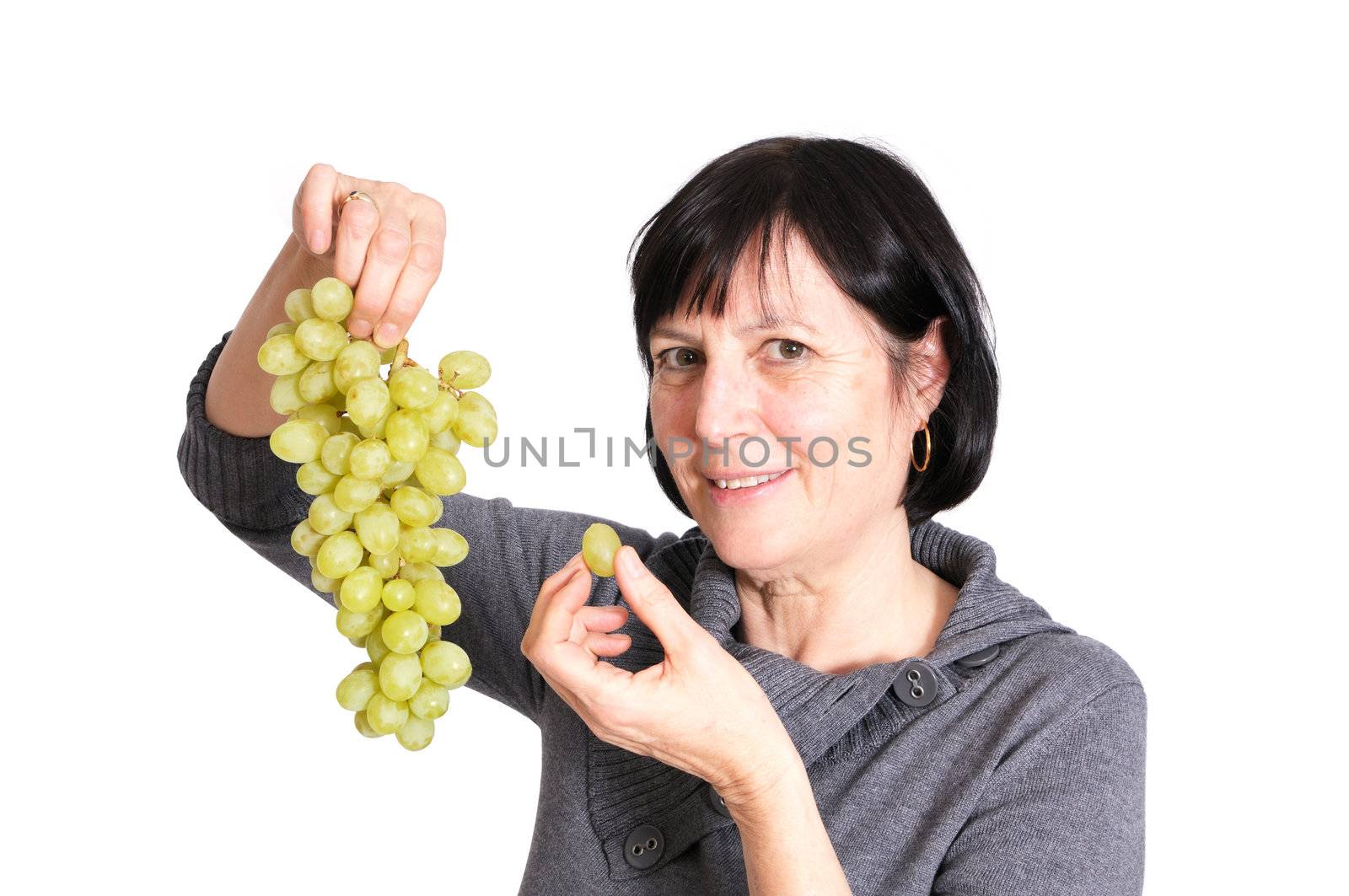 Retired healthy senior woman eating fresh green grapes isolated on white background.