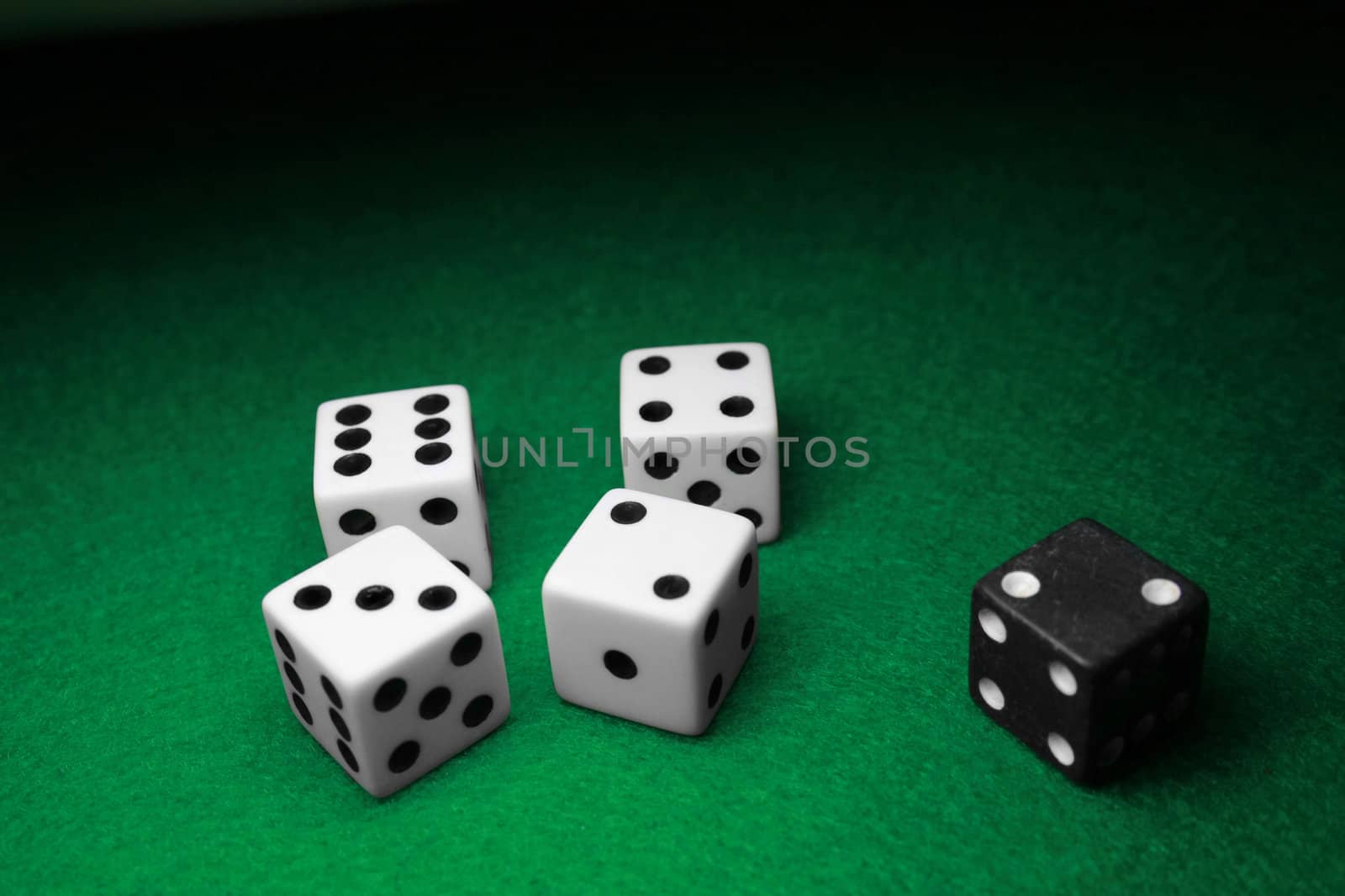 Dice seperated over a table of green felt