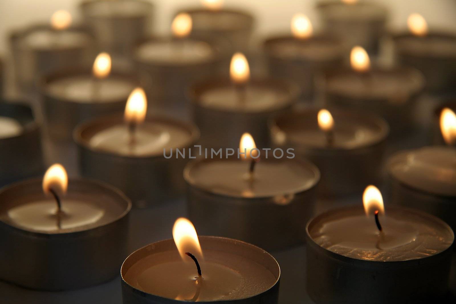 several burning candles, distance blur, warm brown color