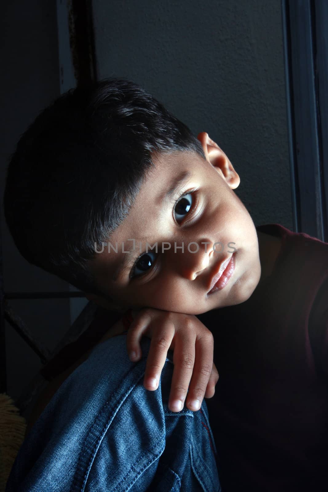 A portrait of an innocent Indian boy in sad mood.