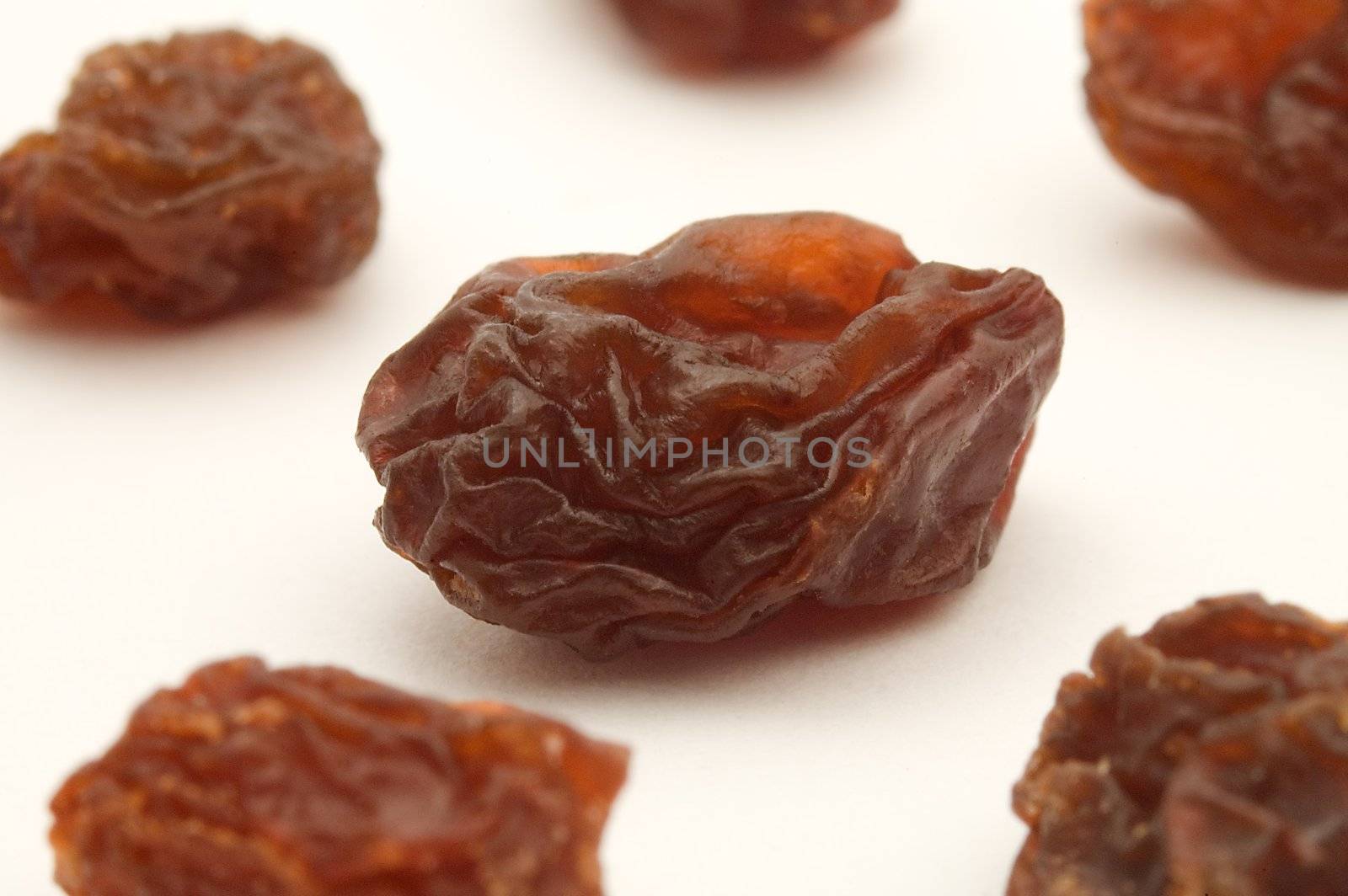 several dried raisins on white background