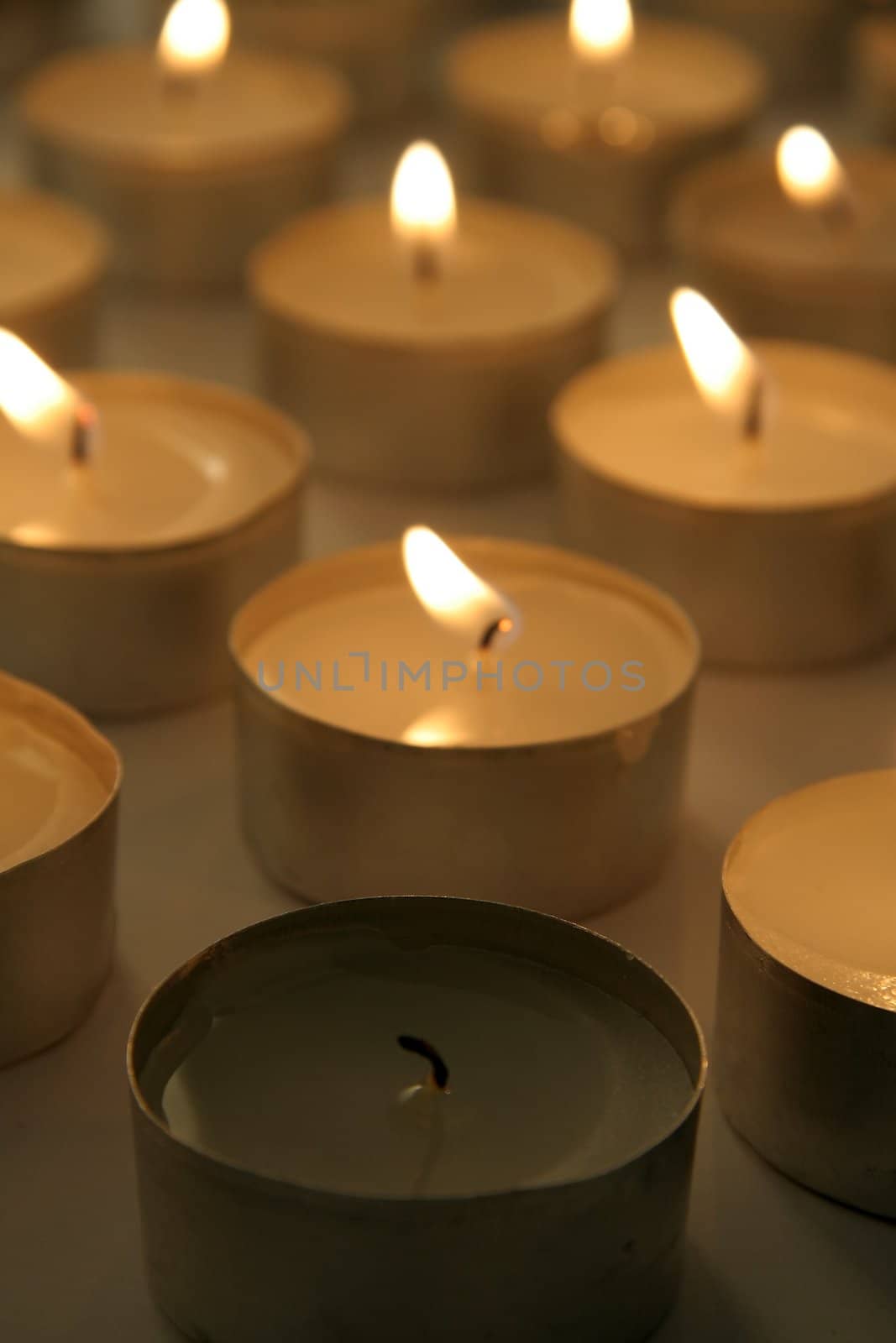 several burning candles, brown color, distance blur