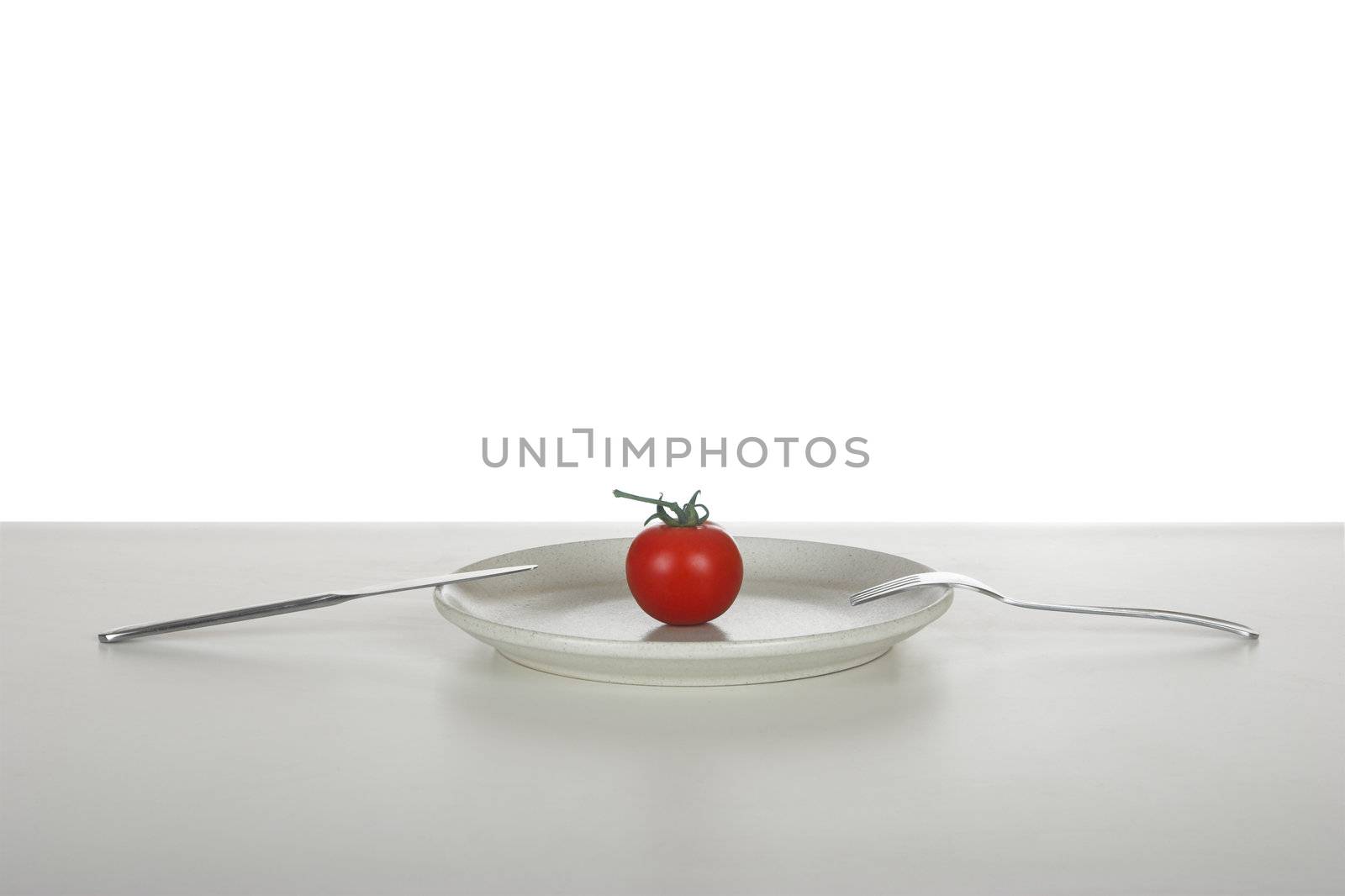 Red tomato in a plate over a table reday to be eaten