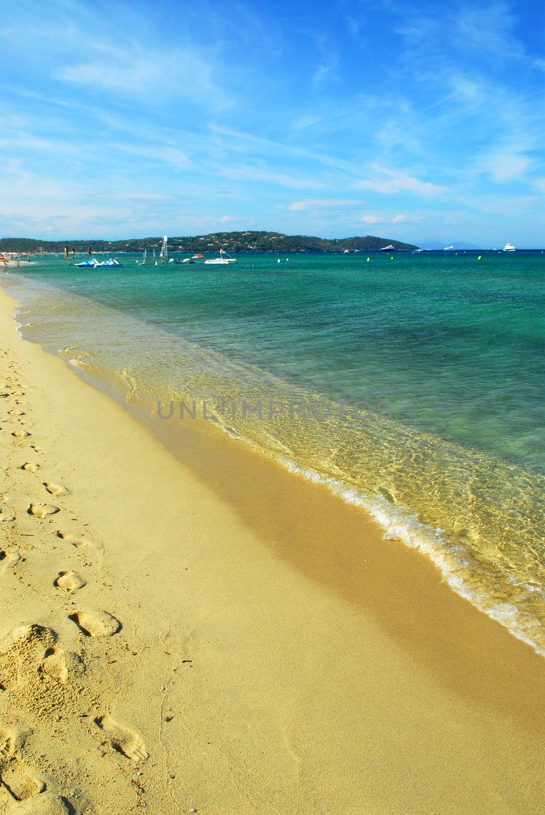 Footprints on the golden sand of famous Pampelonne beach near St. Tropez in French Riviera