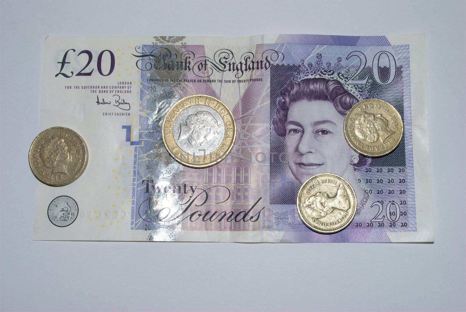 Twenty pound note with coin on top