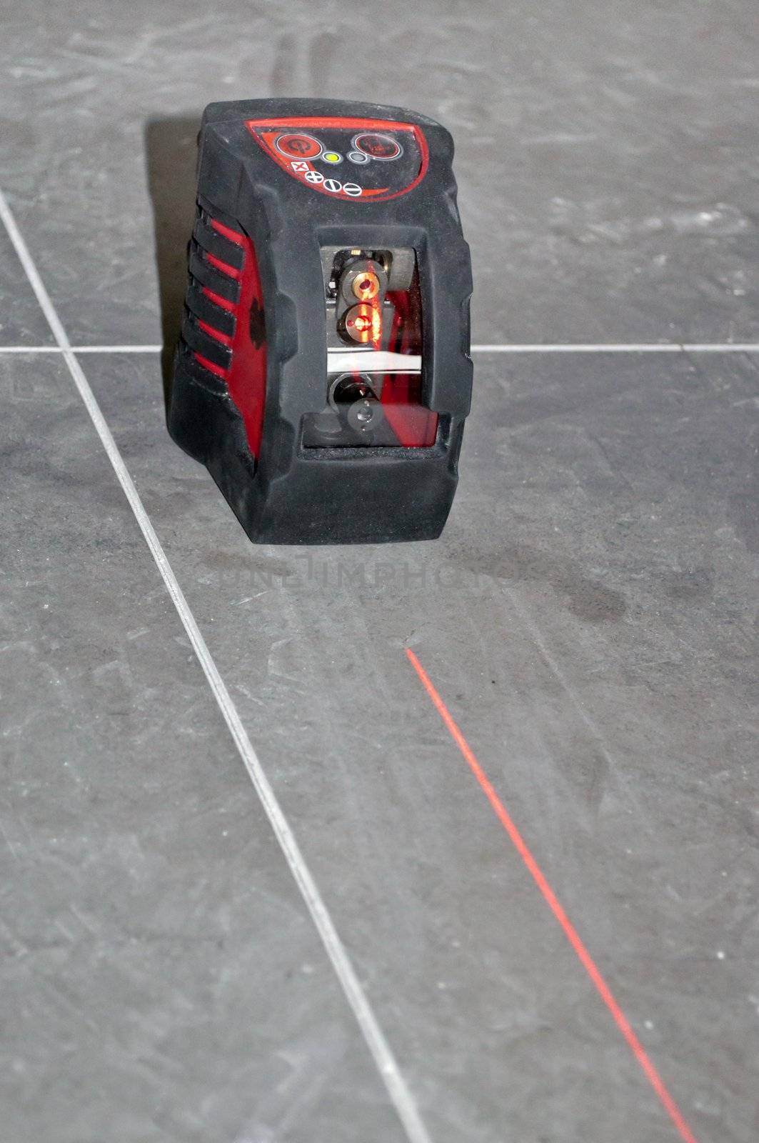 laser level tool with laser beam black on floor