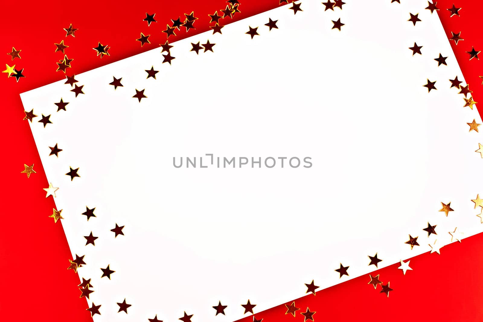 On a red background white greeting card with golden stars.
