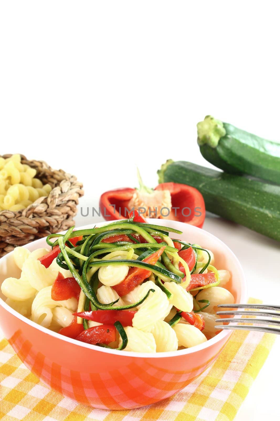 vegetarian pasta with zucchini and peppers on a white background