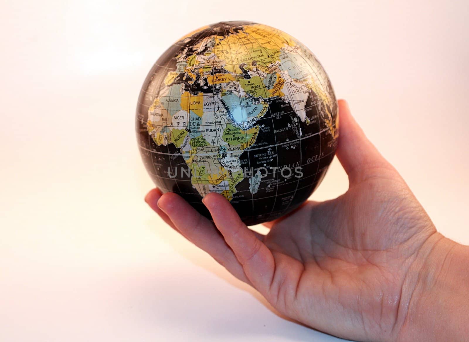 Global peace and global economy with a hand holding a globe isolated on a white background. Business, investment and prosperity for economic growth.