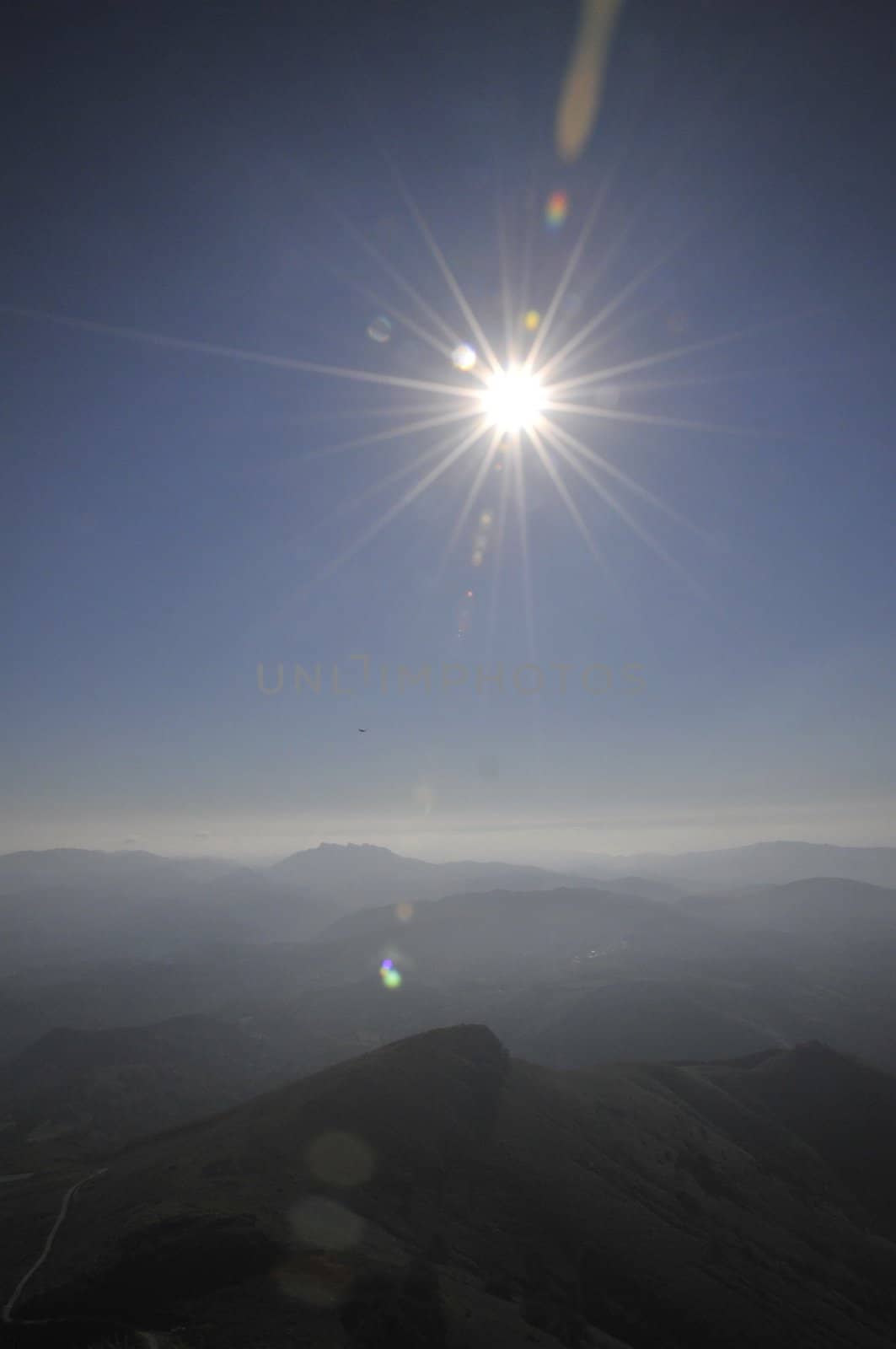 Hard sun with rays above french Pyrenees mountains