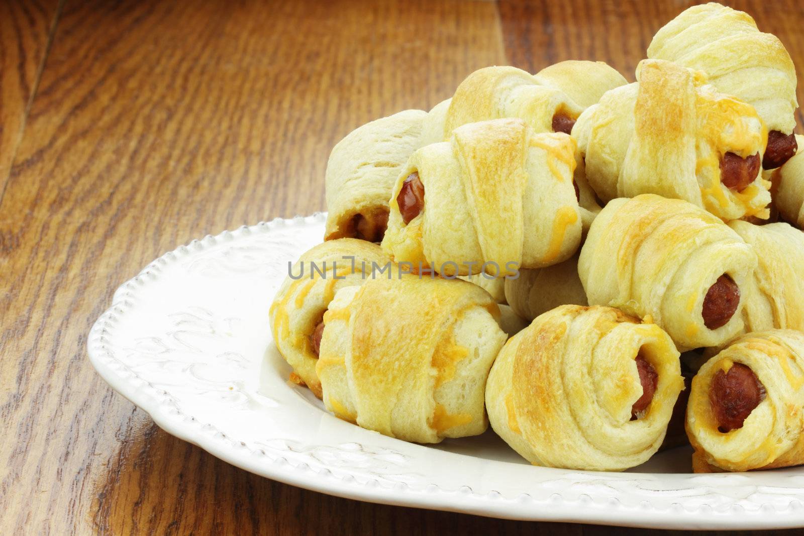 Plate of sausage rolls on a rustic wooden table.
