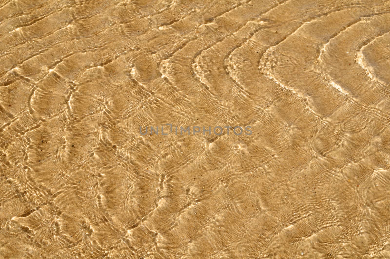 Water ripple on sandy beach for background use.