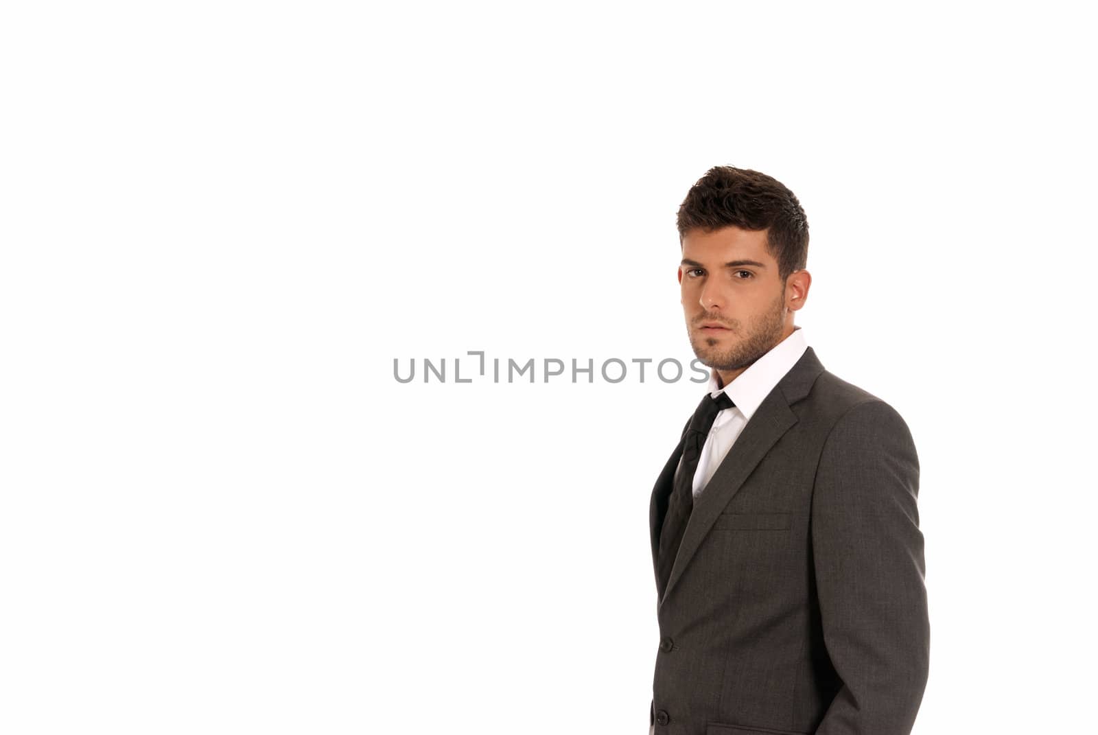 Young businessman with copy-space looking serious isolated on white background by dgmata