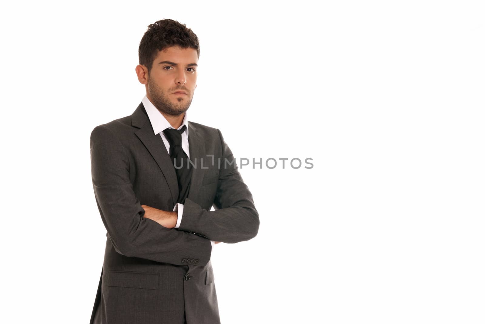 Young businessman with copy-space looking serious arms crossed isolated on white background by dgmata