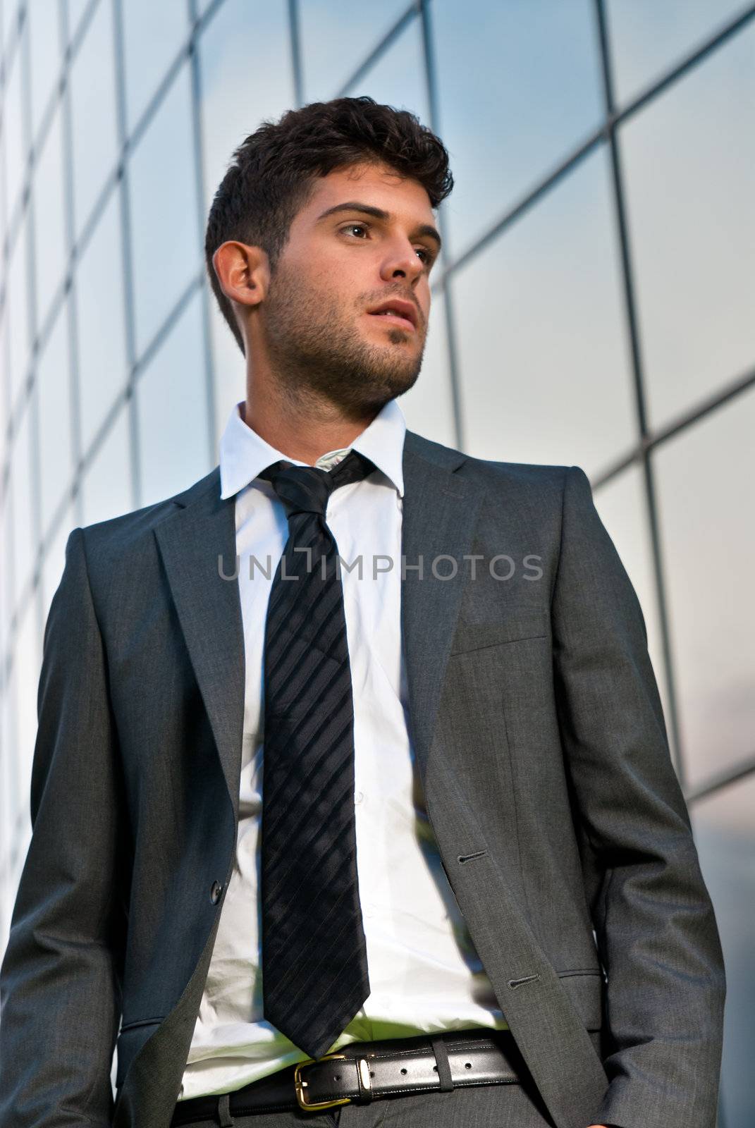 Young businessman looking to good future on modern building background