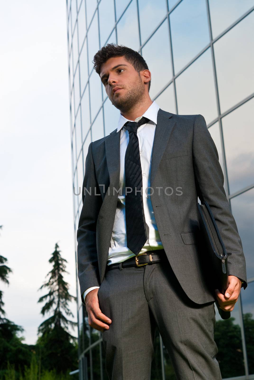 Young businessman looking to good future on modern building background