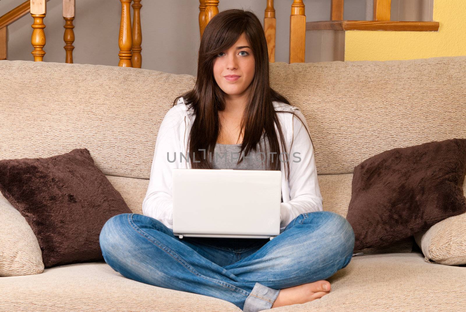 Young woman with laptop portable computer sitting on sofa