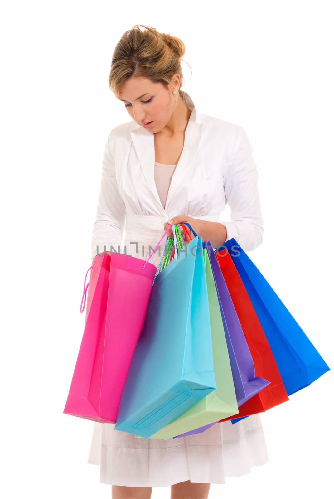 Young woman with shopping bags standing looking into bag isolated on white background by dgmata
