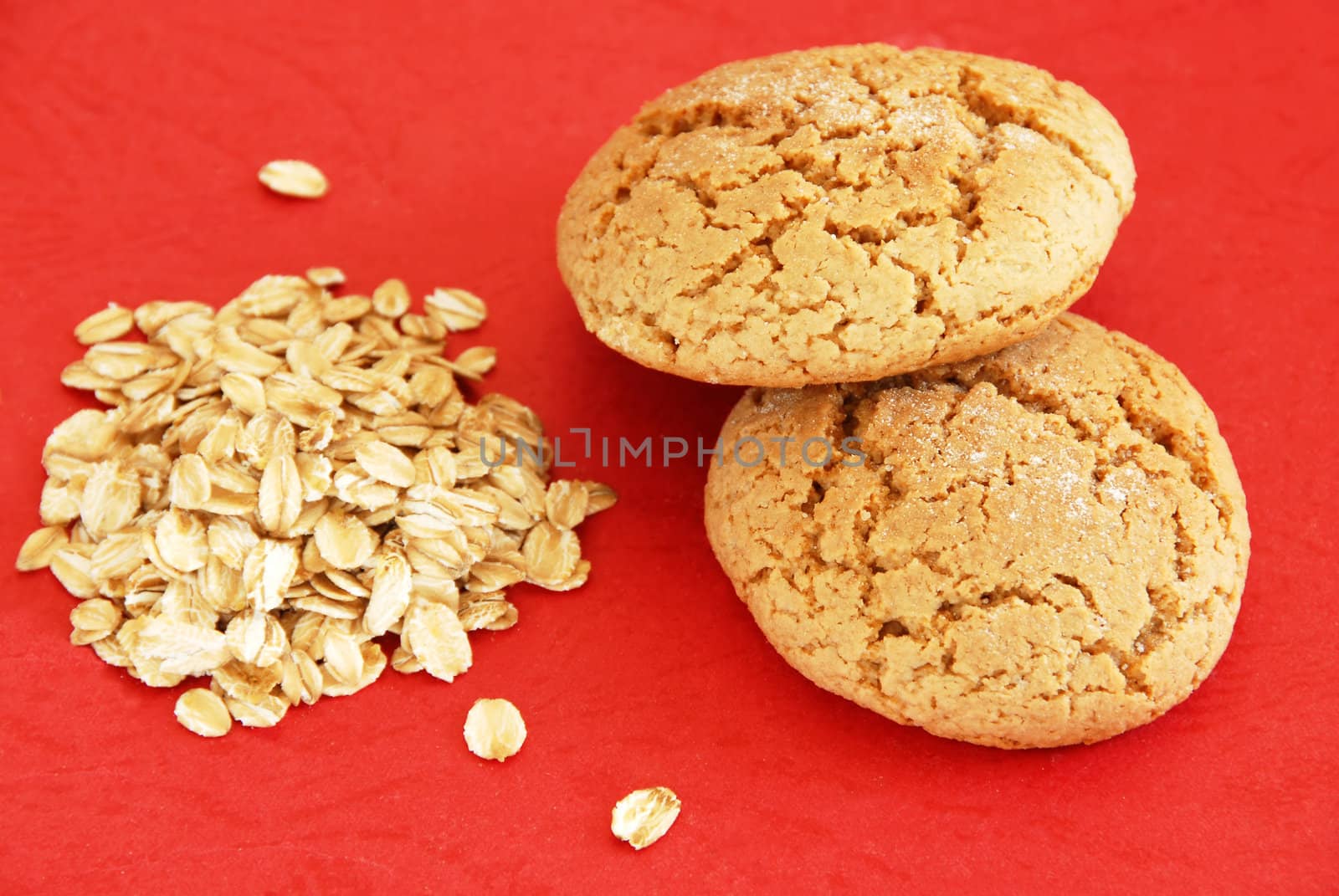 two fresh appetizing oatmeal cookies over red background