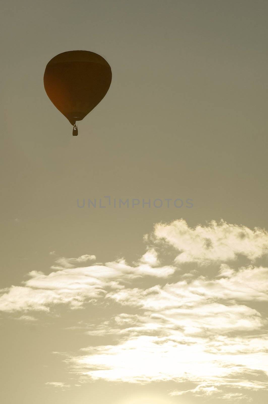 red balloon silhouette on grey sky with clouds