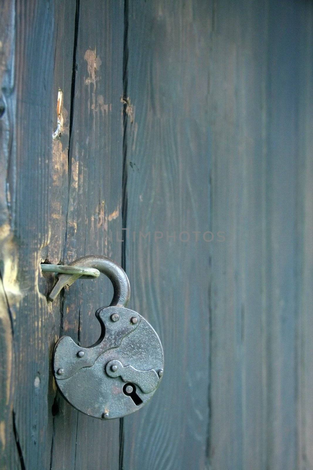detail photo of an old open lock on wooden door,
