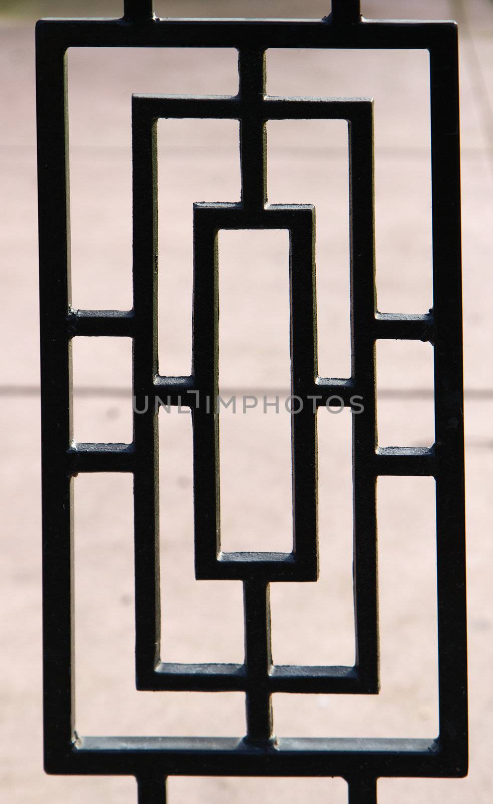 black, near silhouette, of a portion of a deco designed wrought iron gate