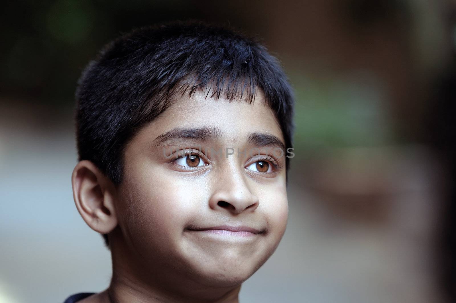 An adorable young Indian boy day dreaming