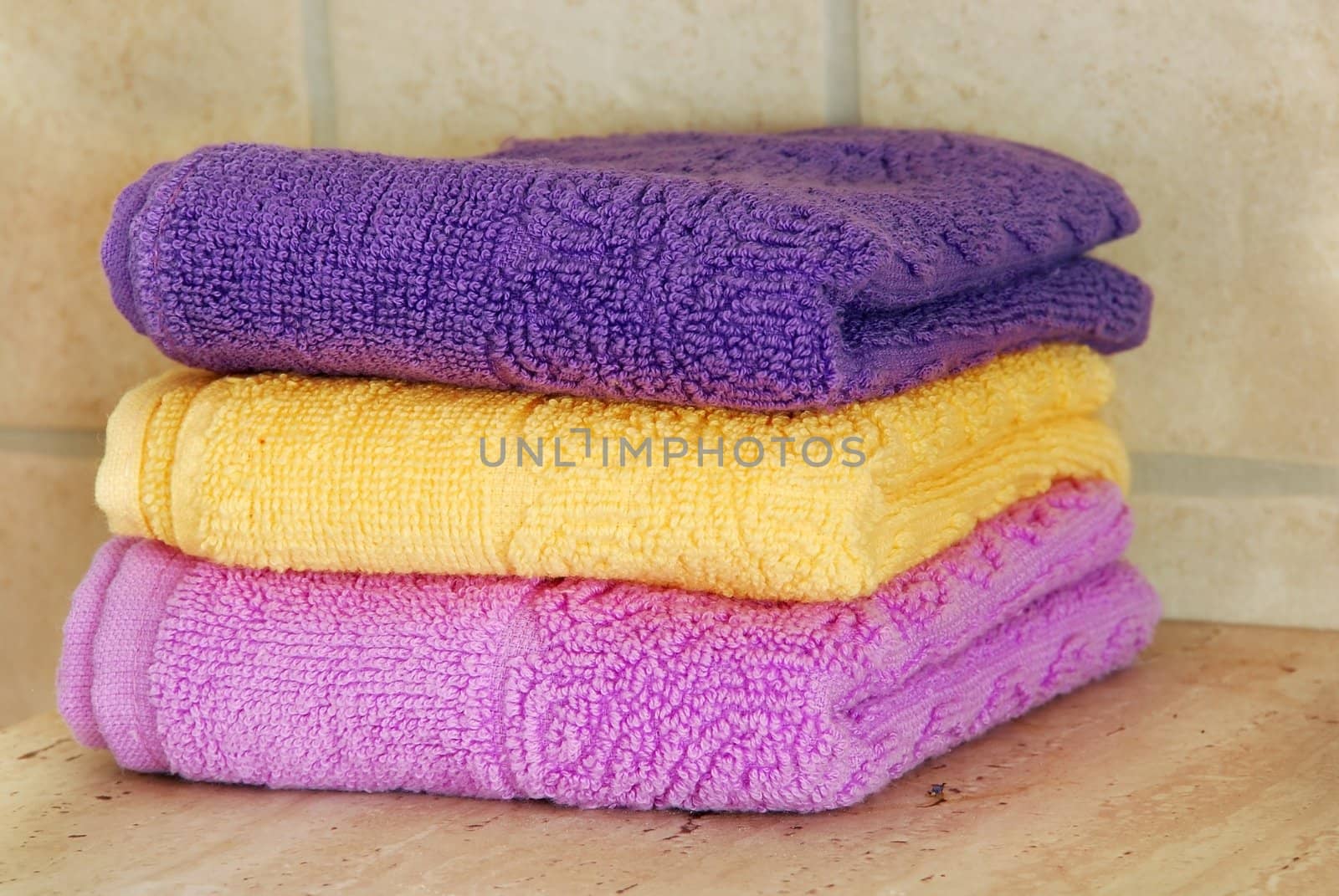 pile of new yellow, magenta and purple cotton towels