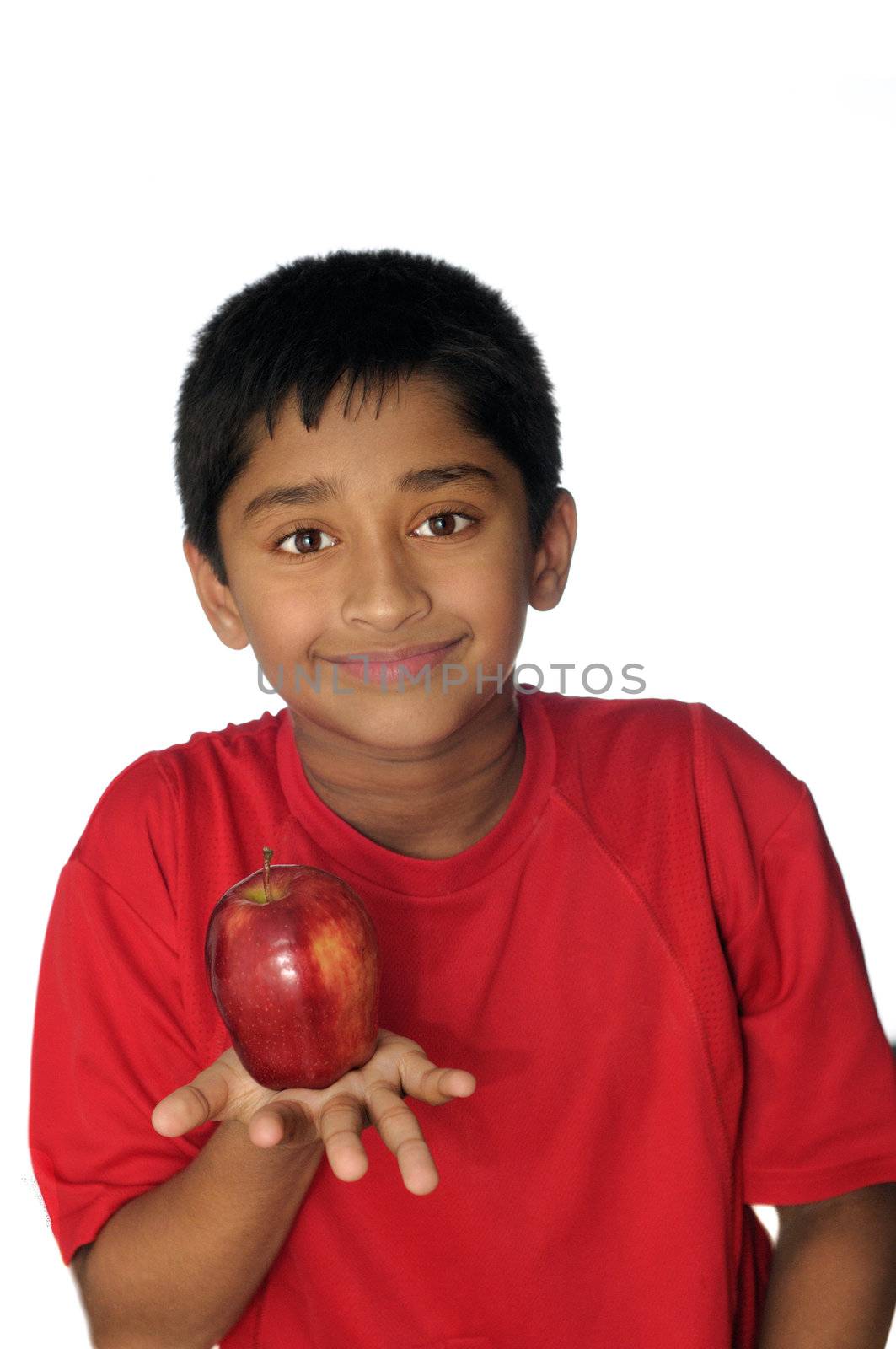 An handsome Indian kid eating apple a day