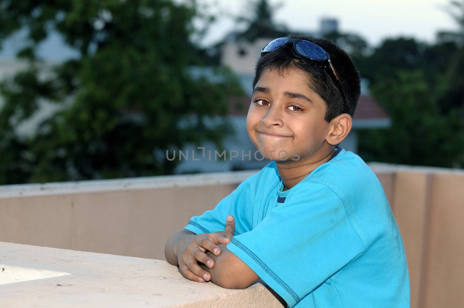 A handsome Indian kid model posing with his sun glasses